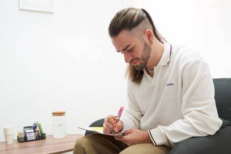 rubén escribiendo en libreta y sonriendo