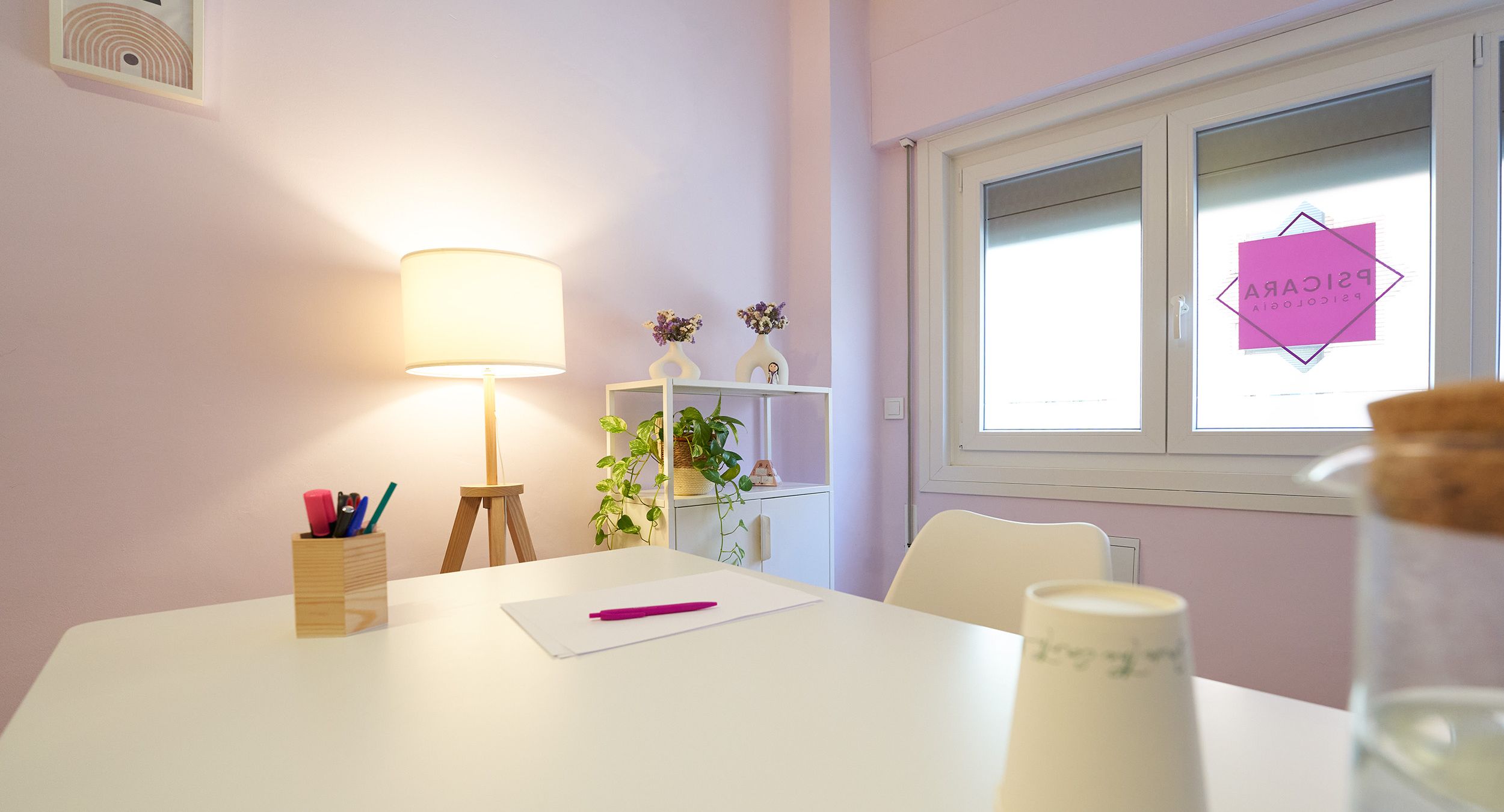 Sala despacho de Teruel con pared rosa y agua en mesa 