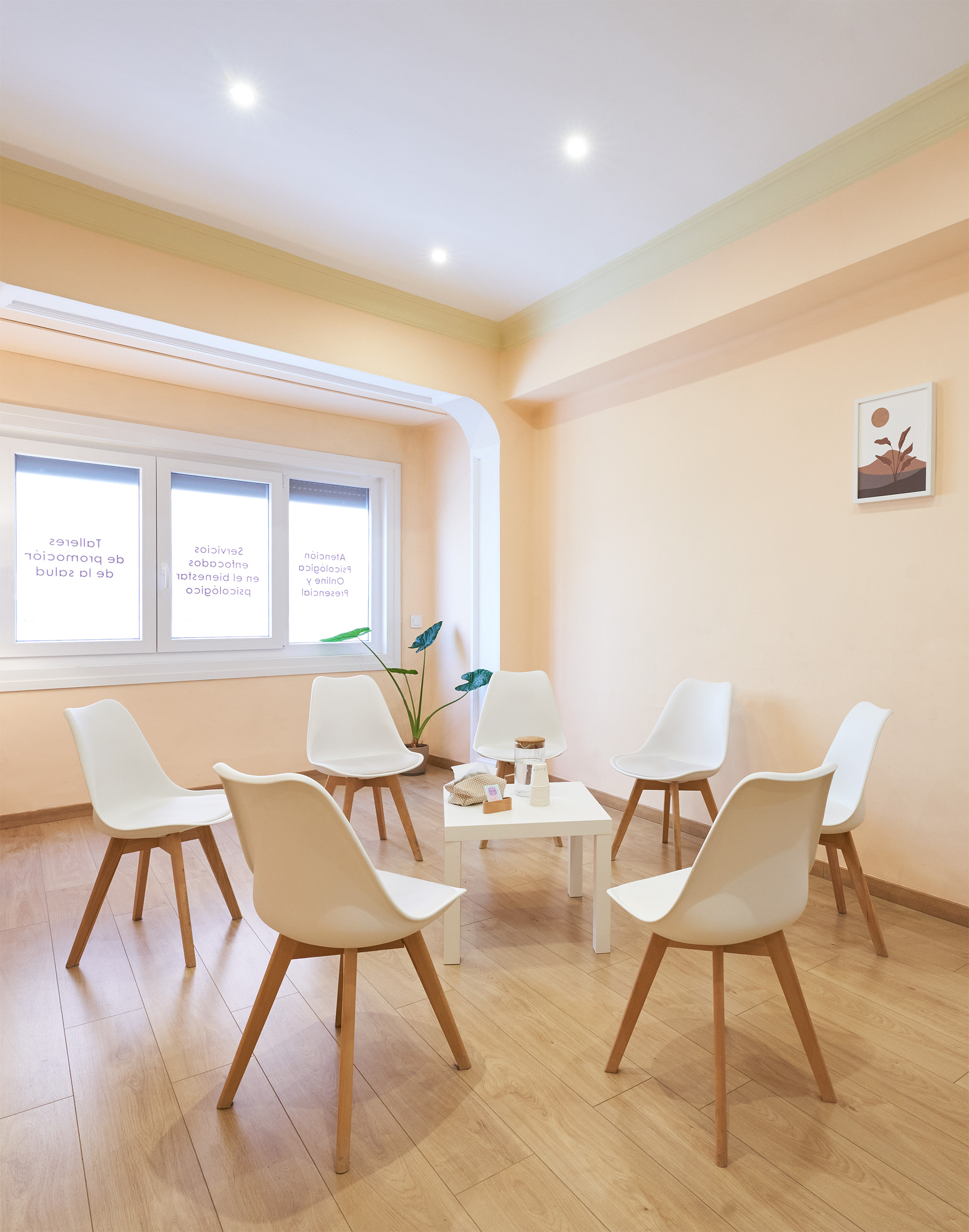 Sala de espera y de reuniones con sillas en círculo y mesa al centro 