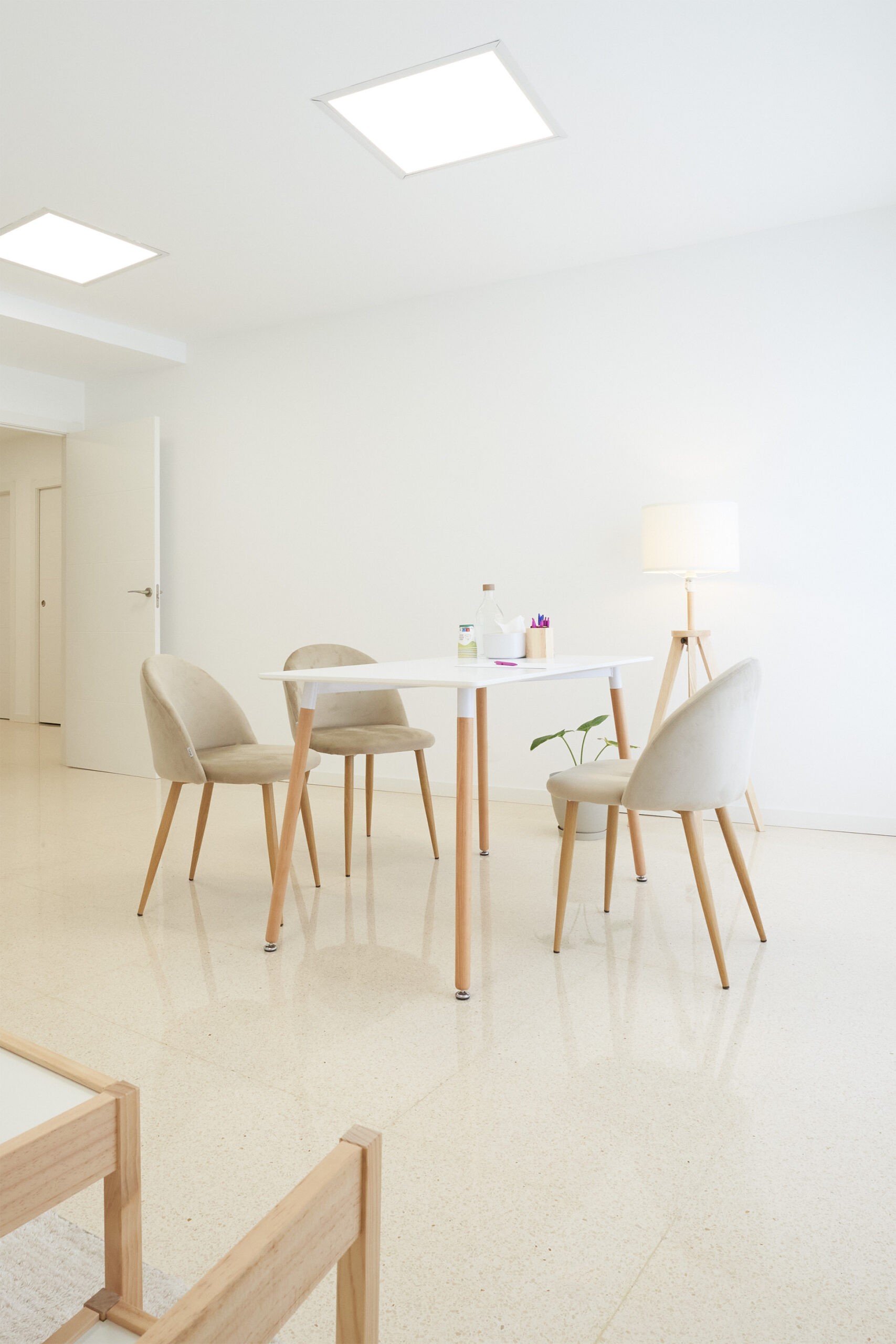 Sala principal con mesa y cuatro sillas en espacio blanco y amplio