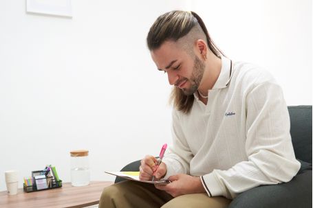 rubén escribiendo en libreta y sonriendo 