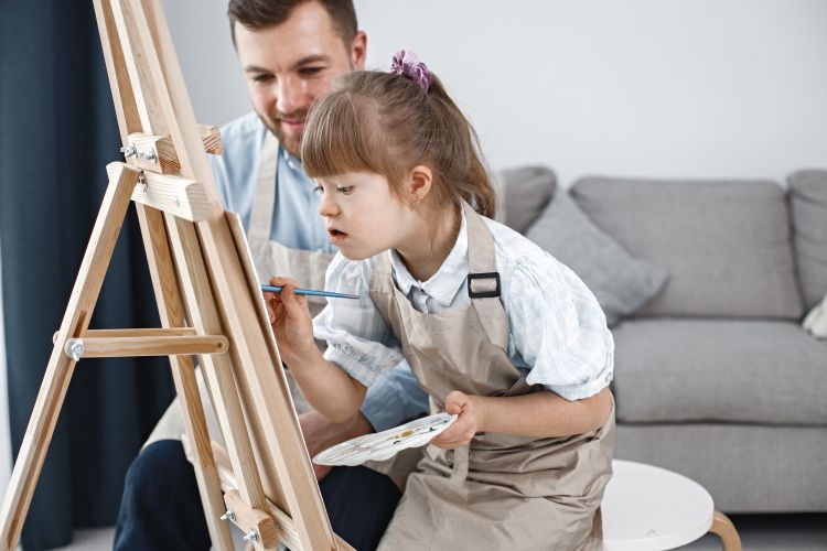 hija con su padre pintando un cuadro 