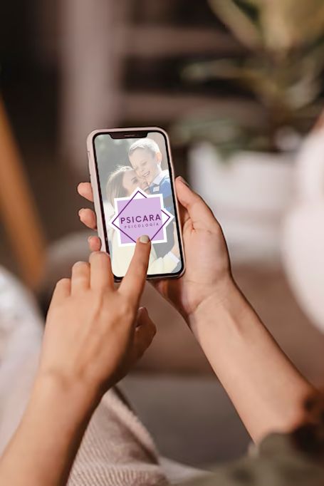 manos con telefono viendo la web de psicara 