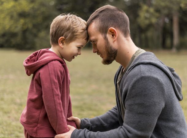 padre e hijo sonriendo de la mano 